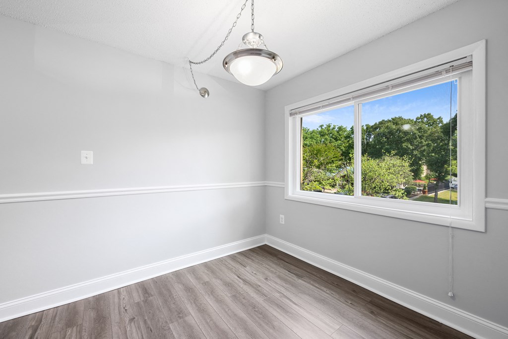 an empty bedroom with a large window and wood flooring at Stuart Woods* Apartments, Herndon, VA, 20170