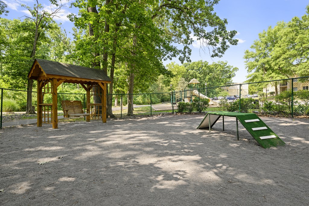 a picnic area with a picnic table and a bench in a park at Stuart Woods* Apartments, Herndon