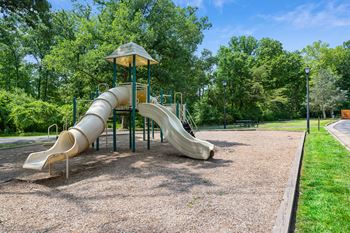 a playground with a slide in a park at Stuart Woods* Apartments, Herndon, 20170