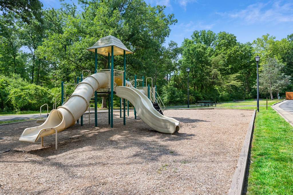 a playground with a slide in a park at Stuart Woods* Apartments, Herndon, Virginia