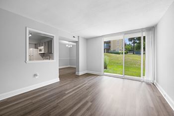 an empty living room with a large window and wood flooring at Stuart Woods* Apartments, Virginia