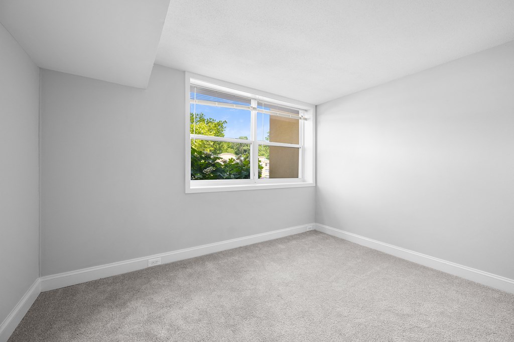 an empty room with white walls and a window at Stuart Woods* Apartments, Virginia