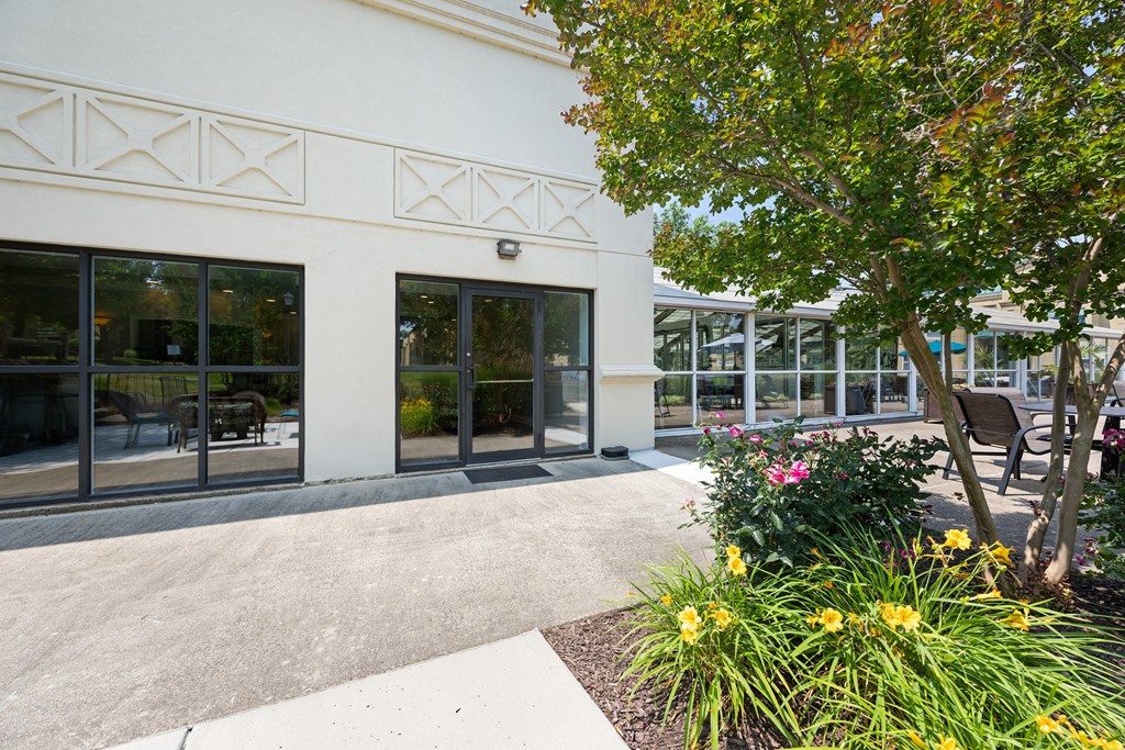 a sidewalk in front of a white building with glass doors at Stuart Woods* Apartments, Herndon, VA, 20170