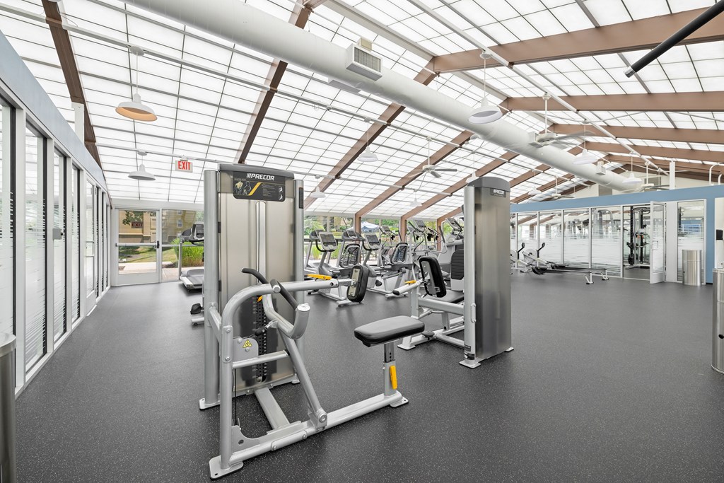 a gym with weights and cardio equipment and glass ceilings at Stuart Woods* Apartments, Virginia