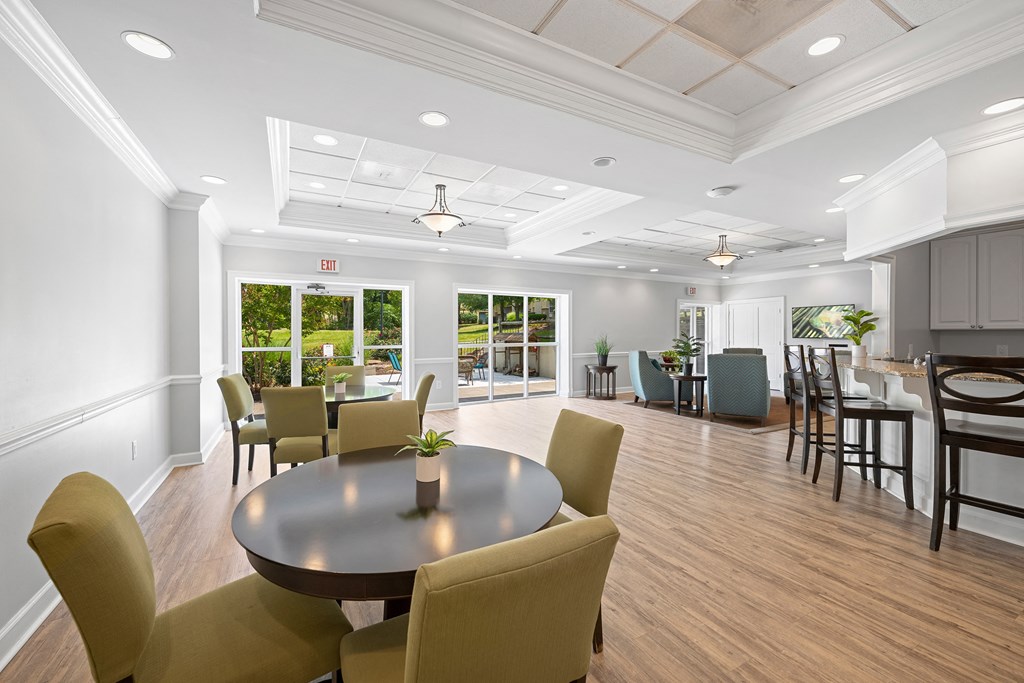 a large room with a table and chairs and a kitchen at Stuart Woods* Apartments, Herndon