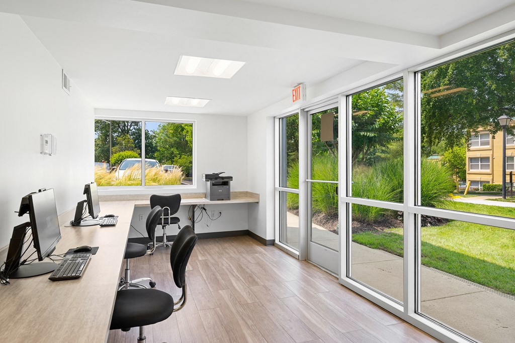 an office with windows and a desk with chairs and a computer at Stuart Woods* Apartments, Herndon
