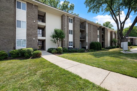 Apartment complex with a tree in front.