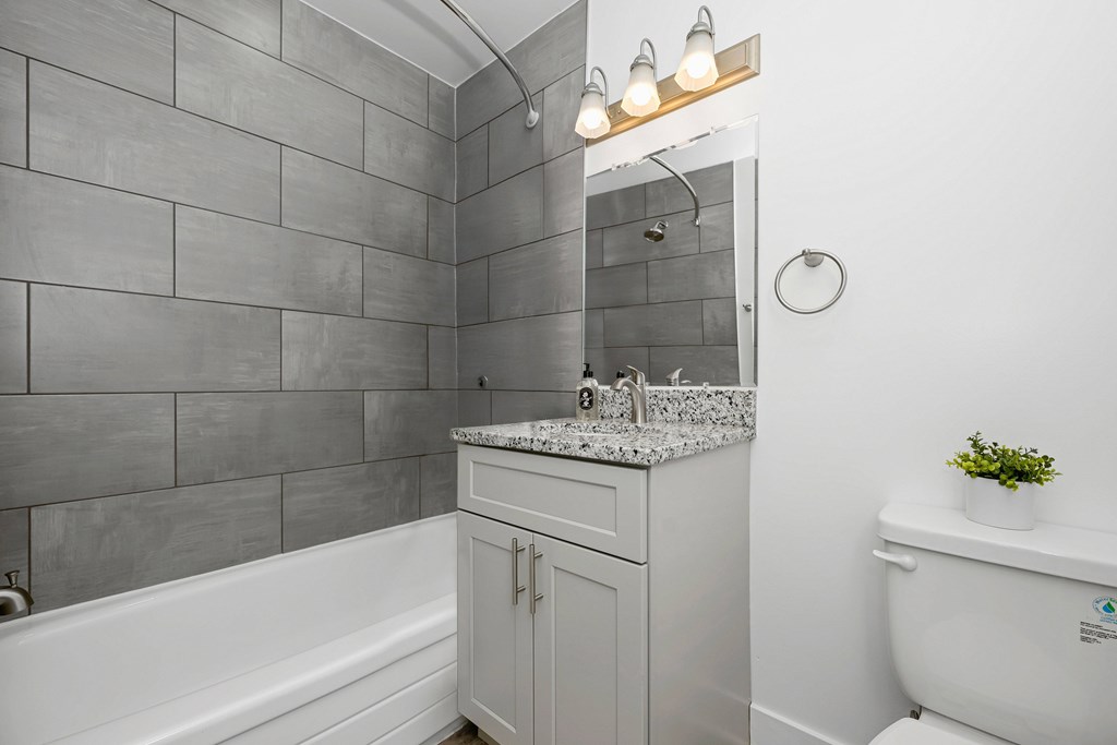 A bathroom with a white tub, sink, and toilet at Gainsborough Court Apartments, Fairfax, VA