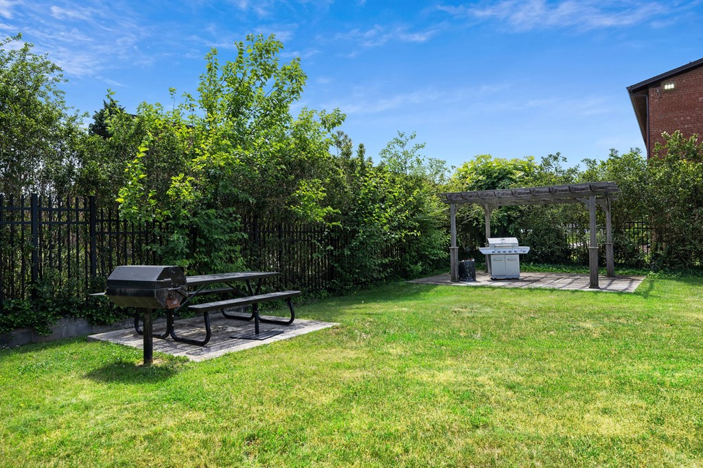 A picnic table is in the middle of a grassy area at Rose Hill Apartments, Virginia