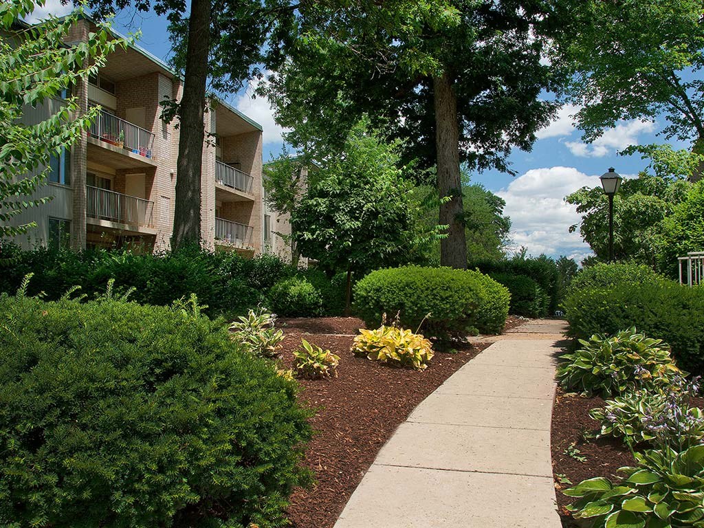 Walkway with lush green landscaping at Tysons Glen Apartments and Townhomes, Virginia