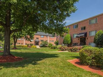Exterior of apartment building with green landscaping at Woodlee Terrace Apartments, Virginia, 22192 - Photo Gallery 2