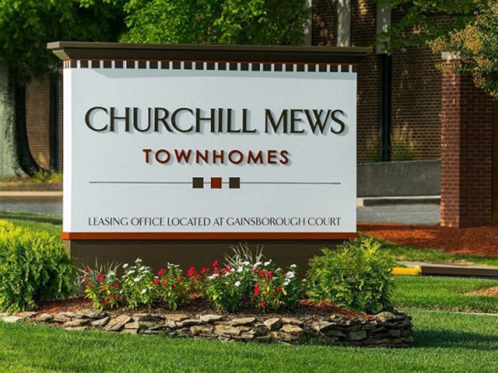 A sign for Churchill Mews Townhomes with a leasing office