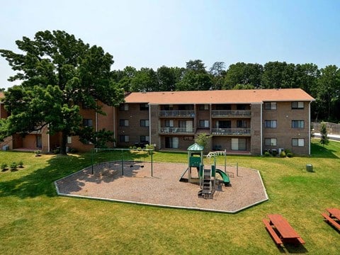 Far away view of apartment complex with playground at Gainsborough Court Apartments, Fairfax, VA