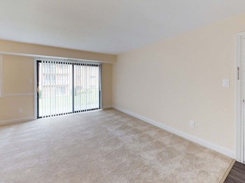View of large living room area in apartment building with carpeting at Gainsborough Court Apartments, Fairfax, VA, 22030 - Photo Gallery 13