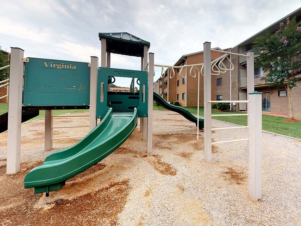A playground with a green slide and a Virginia sign at Gainsborough Court Apartments, Fairfax, VA, 22030
