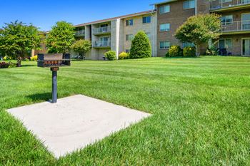 a mailbox in the middle of a lawn in front of an apartment building at Gainsborough Court Apartments, Virginia, 22030