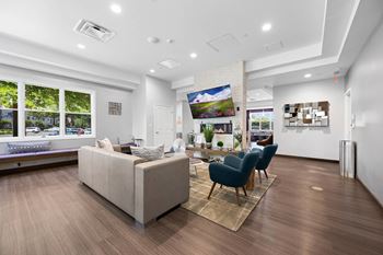 A living room with a white couch and a blue chair at Rose Hill Apartments, Alexandria, VA