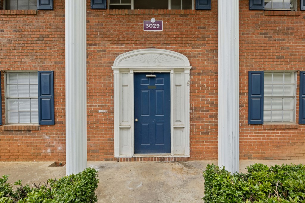 the front of a brick building with a blue door