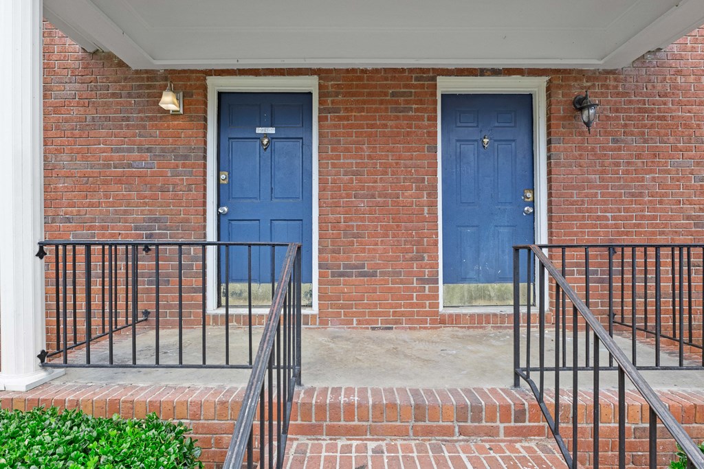 two blue doors on the side of a brick building
