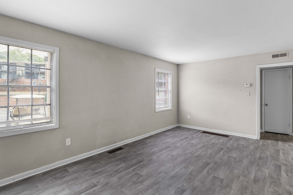 the living room of an empty house with a window and a door