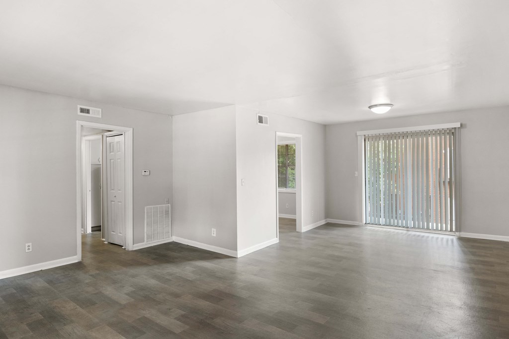 the living room and dining room of an empty house with white walls