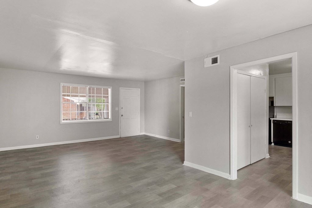 an empty living room with white walls and a window