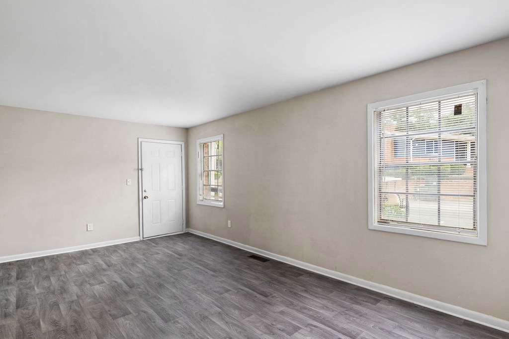 the living room of an apartment with a window and a door