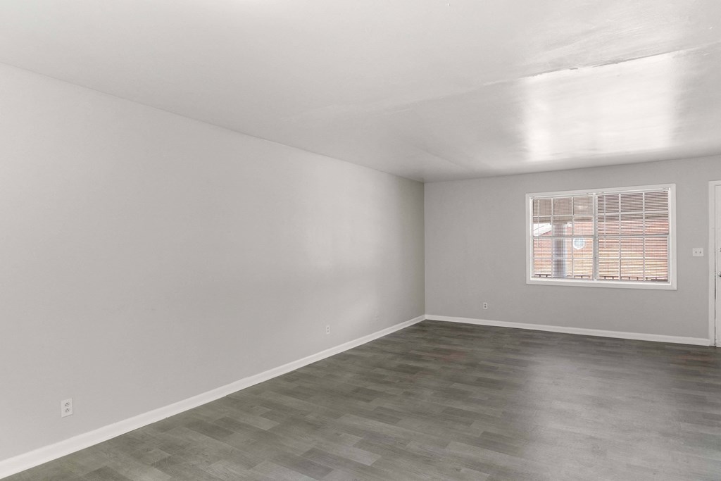 the living room of an apartment and white walls and a window