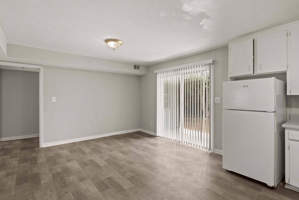 a kitchen and living room with white appliances and a sliding glass door