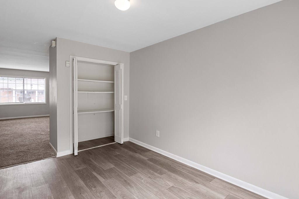 an empty bedroom with a closet and a window