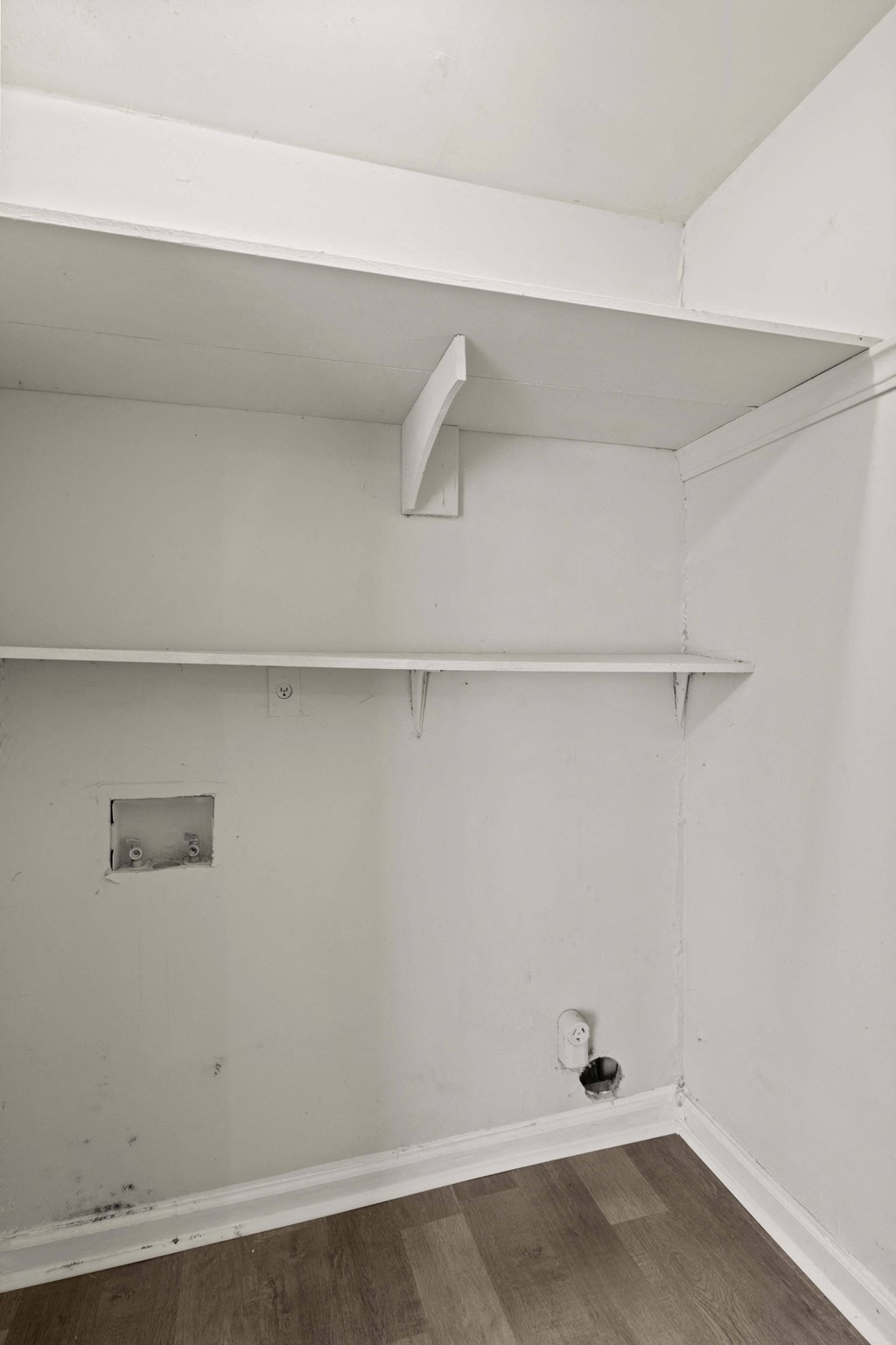 an empty room with white walls and a white shelf on the wall