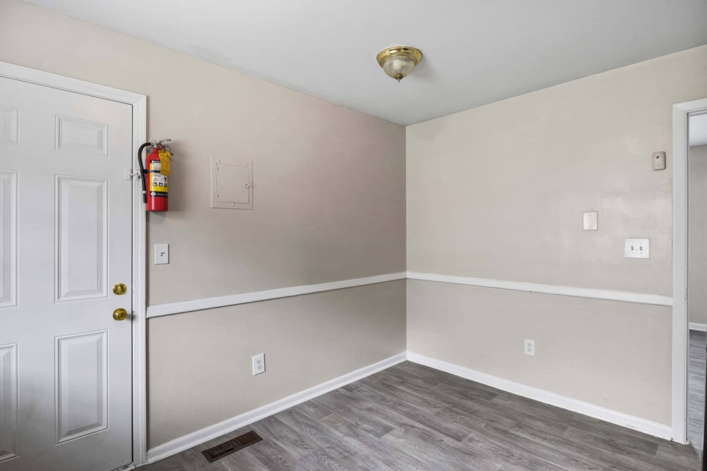 an empty room with a door and a fire hydrant on the wall
