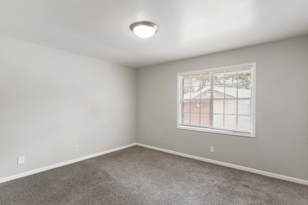 an empty room with carpet and a window