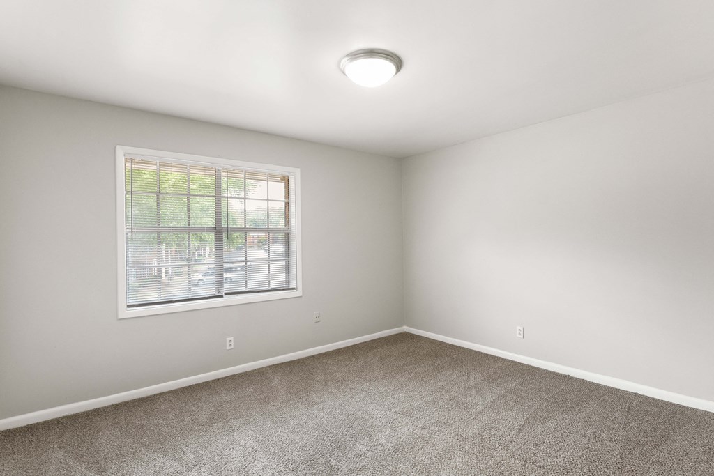 an empty room with carpet and a window