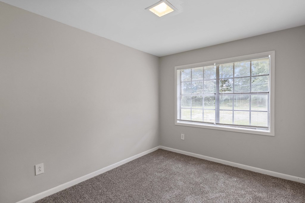 an empty room with carpet and a window