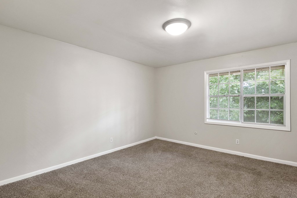 an empty room with carpet and a window