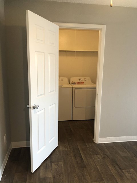 A white door is open to a small kitchen.