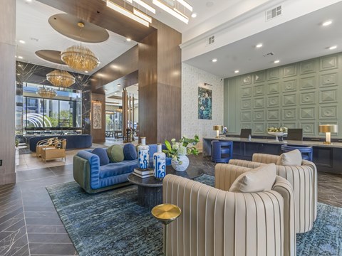 A modern living room with a blue sofa and striped armchairs.