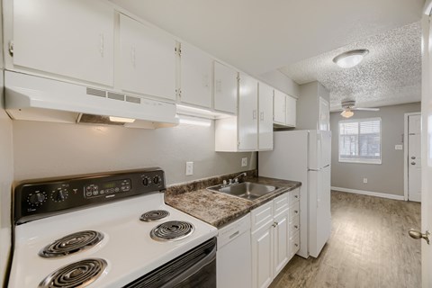 A kitchen with white cabinets and a stove top oven.