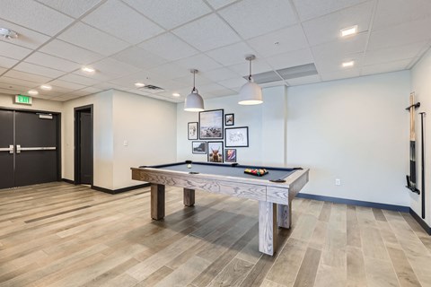 A room with a pool table and a bench.