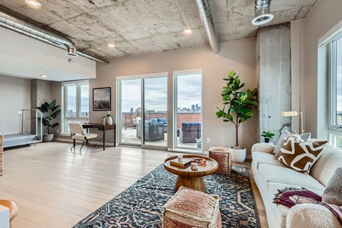A living room with a white couch and a rug with a blue pattern.