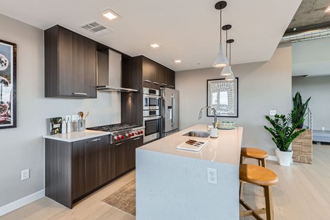 A modern kitchen with dark brown cabinets and a white island.
