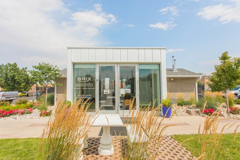 the exterior of a building with glass doors and a table outside