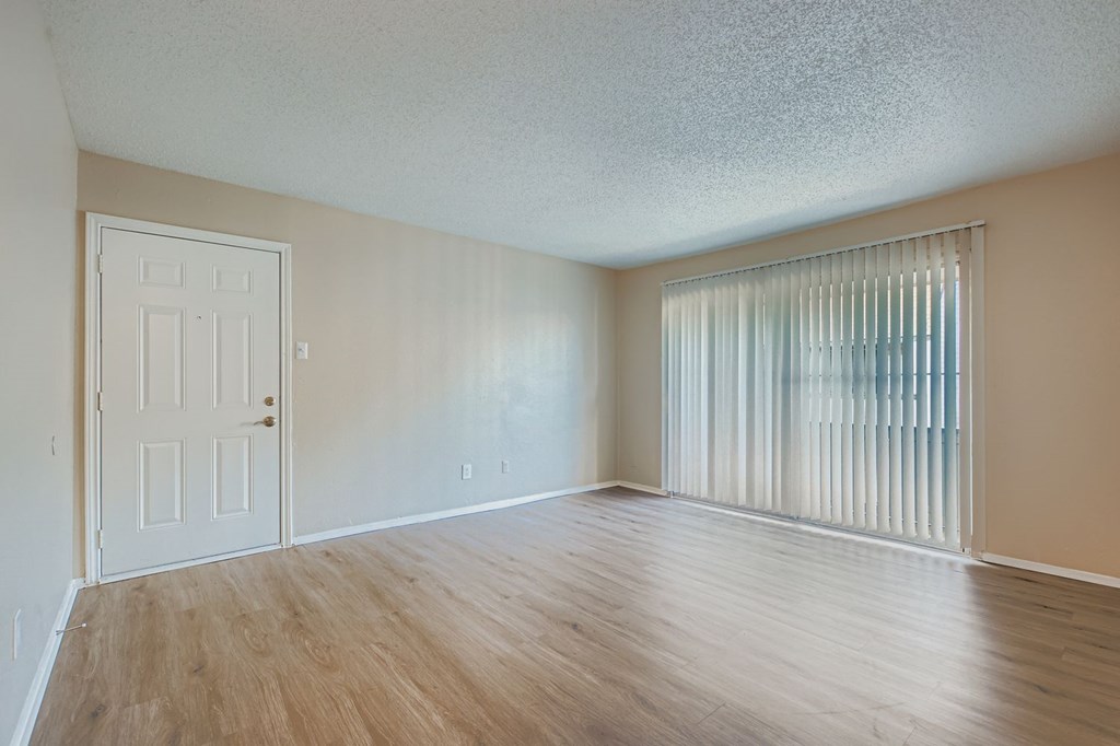 A room with a white door and a window with blinds.
