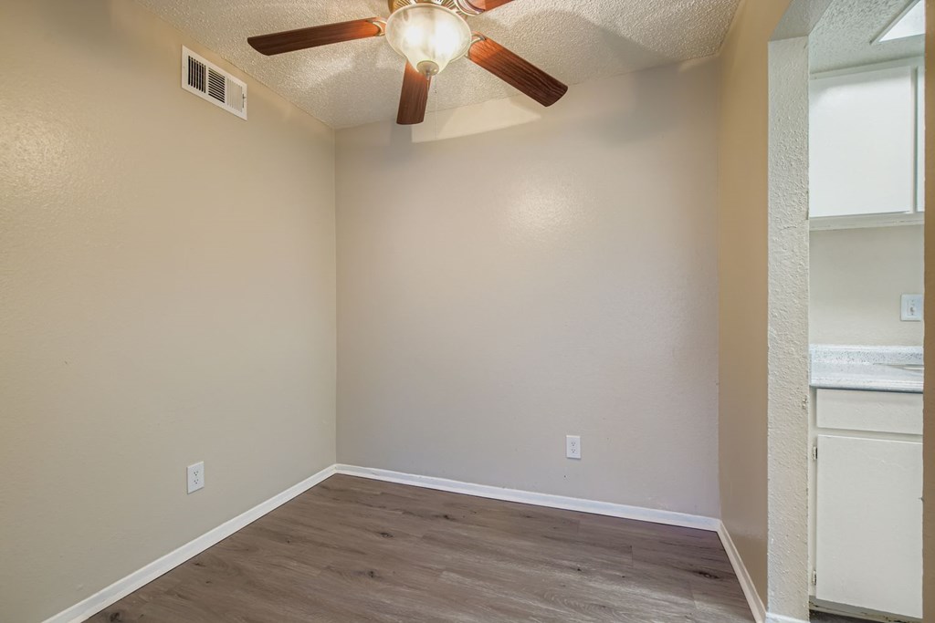 A room with a ceiling fan and light fixture.
