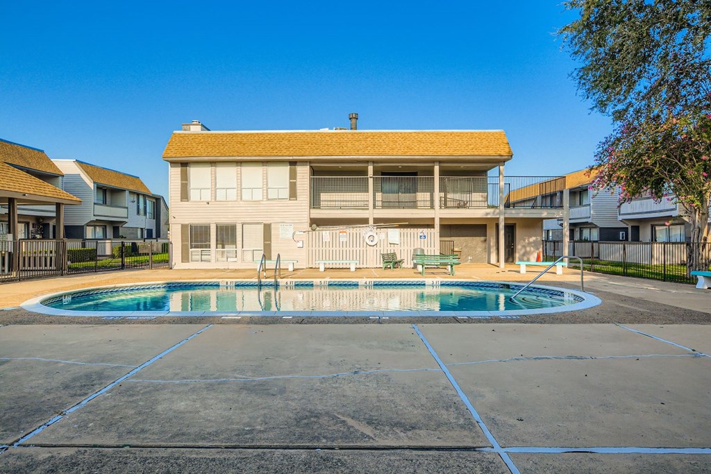 A large house with a pool in front.