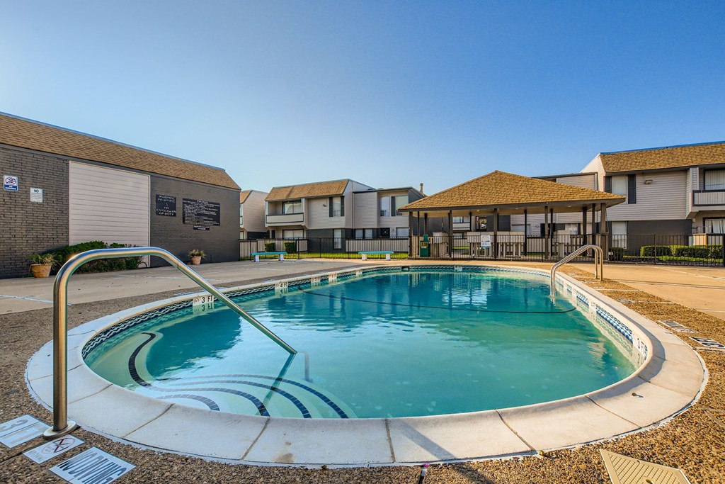 A small pool with a metal ladder sits in the middle of a courtyard.