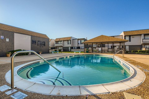 A small pool with a metal ladder sits in the middle of a courtyard.