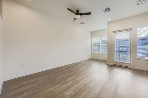 A room with a ceiling fan and wooden flooring.