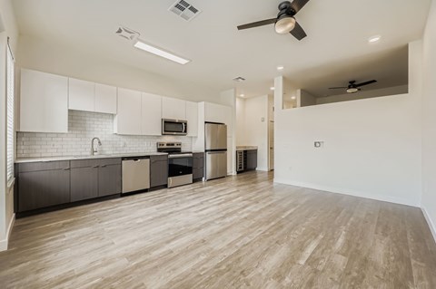 A spacious kitchen with wooden floors and modern appliances.